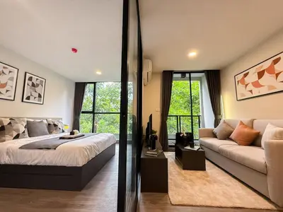 a bedroom with a bed and a couch at Serene Tropical 1BR - Ultra Fast Wifi - Sathorn in Bangkok