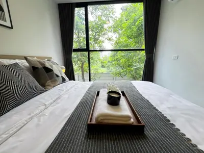 a tray with a candle on a bed with a window at Serene Tropical 1BR - Ultra Fast Wifi - Sathorn in Bangkok
