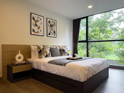 a bedroom with a large bed and a large window at Serene Tropical 1BR - Ultra Fast Wifi - Sathorn in Bangkok