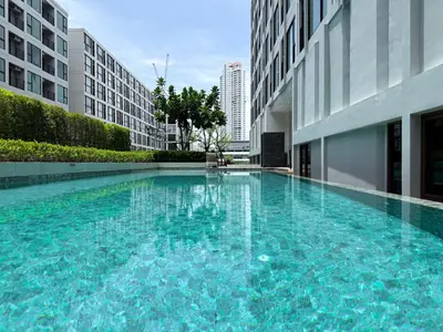 a large swimming pool in the middle of a building at Stylish Tropical l 2BR - Ultra Fast Wifi - Sathorn in Bangkok