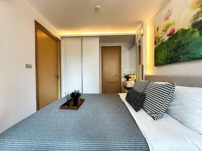 a bedroom with a large bed with pillows on it at Contemporary Premier 1BR - Ultra Fast Wifi - BTS Nana in Bangkok