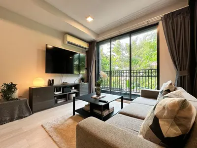 a living room with a couch and a large window at Contemporary Downtown - Ultra Fast WiFi - BTS Asoke in Bangkok