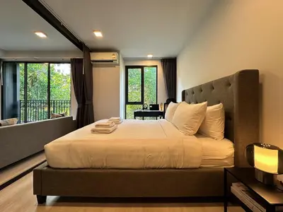 a bedroom with a large bed and a balcony at Contemporary Downtown - Ultra Fast WiFi - BTS Asoke in Bangkok