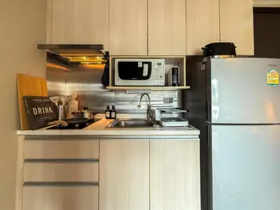 a kitchen with a refrigerator and a sink and a microwave at Tropical Modern 1BR - Ultra Fast Wifi - Thong Lo in Bangkok