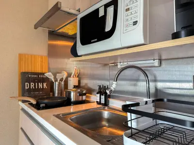 a kitchen with a sink and a microwave at Tropical Modern 1BR - Ultra Fast Wifi - Thong Lo in Bangkok