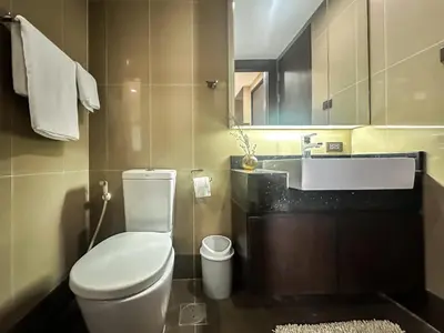 a bathroom with a toilet and a sink at Tropical Modern 1BR - Ultra Fast Wifi - Thong Lo in Bangkok