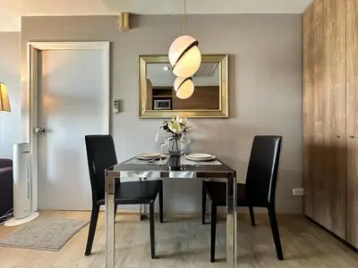 a dining room with a table and black chairs at Exclusive Cityscape - Ultra Fast WiFi - BTS Thong Lor in Bangkok