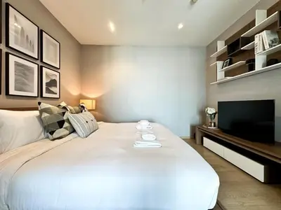 a bedroom with a large white bed and a flat screen tv at Exclusive Cityscape - Ultra Fast WiFi - BTS Thong Lor in Bangkok