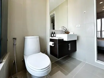 a bathroom with a white toilet and a sink at Exclusive Cityscape - Ultra Fast WiFi - BTS Thong Lor in Bangkok