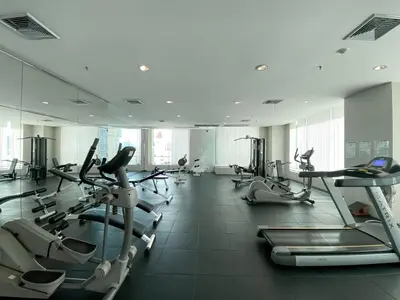 a gym with a large room with cardio machines at Centralized High-Rise - Ultra Fast Wifi - Ratchathewi in Bangkok