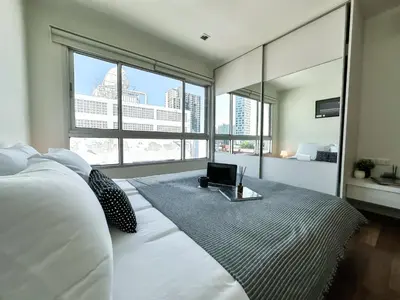 a bedroom with a bed with a laptop on it at Contemporary Modern 1BR - Ultra Fast WiFi - On nut in Bangkok