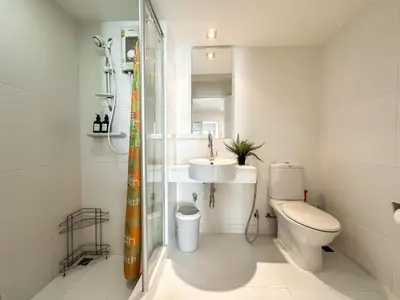 a white bathroom with a toilet and a sink at Contemporary Modern 1BR - Ultra Fast WiFi - On nut in Bangkok