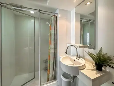 a bathroom with a sink and a shower at Contemporary Modern 1BR - Ultra Fast WiFi - On nut in Bangkok