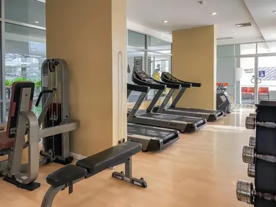 a gym with several treadmills and elliptical machines at Contemporary Modern 1BR - Ultra Fast WiFi - On nut in Bangkok