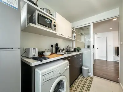 a kitchen with a washer and dryer in it at Contemporary Modern 1BR - Ultra Fast WiFi - On nut in Bangkok