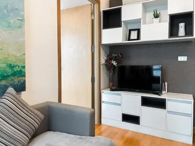 a living room with a couch and a television at Expansive Premier 1BR - Ultra Fast Wifi - Phrom Phong in Bangkok