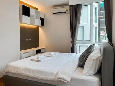 a bed in a room with a large window at Expansive Premier 1BR - Ultra Fast Wifi - Phrom Phong in Bangkok