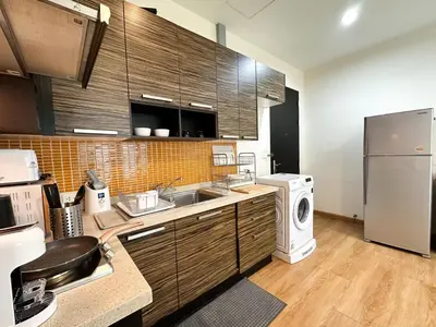 a kitchen with a sink and a washer and dryer at Expansive Premier 1BR - Ultra Fast Wifi - Phrom Phong in Bangkok