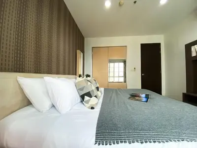 a bedroom with a large white bed with a book on it at Upscale Modern 2BR - Ultra Fast WiFi - BTS Asoke in Bangkok