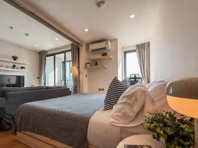 a bedroom with a large bed and a couch at Upscale Skyview 1BR - Ultra Fast Wifi - Chitlom in Bangkok