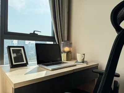 a laptop computer sitting on a desk in front of a window at Upscale Skyview 1BR - Ultra Fast Wifi - Chitlom in Bangkok