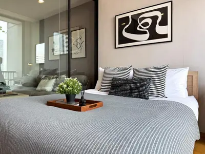 a bedroom with a bed with a table on it at Contemporary Stylish 1BR - Ultra Fast Wifi - Silom in Bangkok