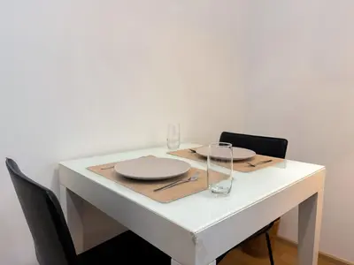 a white table with plates and glasses on it at Modern Expansive - Ultra Fast WiFi - BTS Phrom Phong in Bangkok