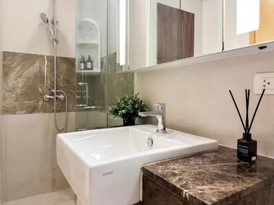a bathroom with a white sink and a shower at Modern Expansive - Ultra Fast WiFi - BTS Phrom Phong in Bangkok