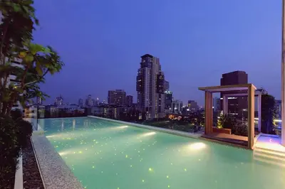 a swimming pool with a city skyline in the background at Modern Expansive - Ultra Fast WiFi - BTS Phrom Phong in Bangkok