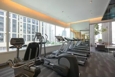a gym with a row of treadmills and elliptical machines at Modern Expansive - Ultra Fast WiFi - BTS Phrom Phong in Bangkok