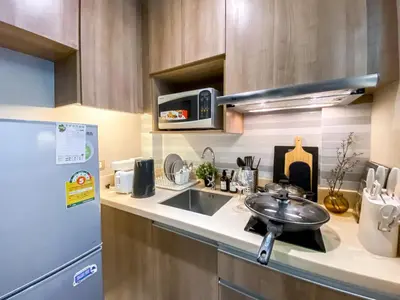 a kitchen with a sink and a refrigerator at Exquisite Modern 1BR - Ultra Fast Wifi - BTS Thong Lo in Bangkok