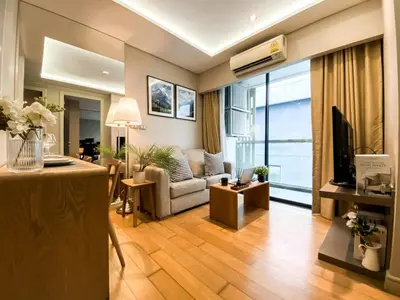a living room with a couch and a tv in it at Exquisite Modern 1BR - Ultra Fast Wifi - BTS Thong Lo in Bangkok