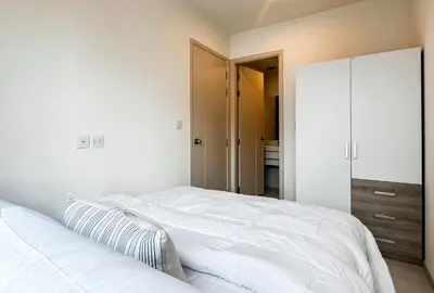 a bedroom with a large white bed and a closet at Luxury City-Scape 2BR - Ultra Fast Wifi - Asoke in Bangkok