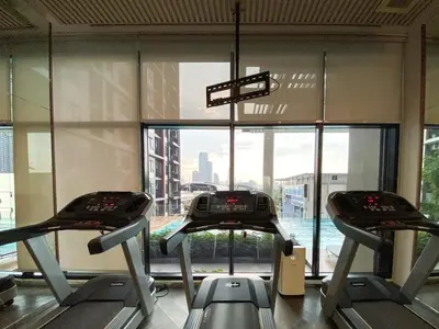 a gym with two cardio machines in front of a window at Luxury City-Scape 2BR - Ultra Fast Wifi - Asoke in Bangkok