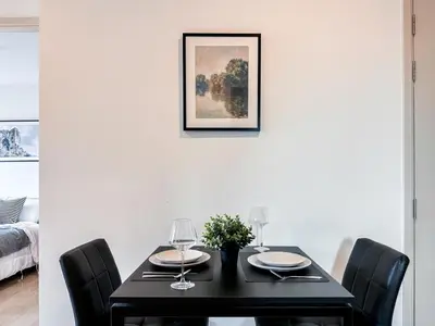 a black dining room table with black chairs and a picture at Luxury City-Scape 2BR - Ultra Fast Wifi - Asoke in Bangkok