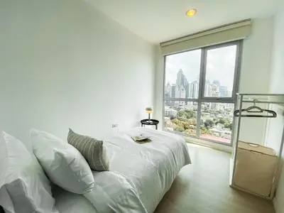 a white bedroom with a bed and a large window at Contemporary High-Rise 2BR - Ultra Fast Wifi - Sathorn in Bangkok