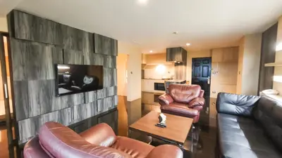 a living room with leather furniture and a flat screen tv at Avana Bangkok Hotel & Convention Centre in Bangna