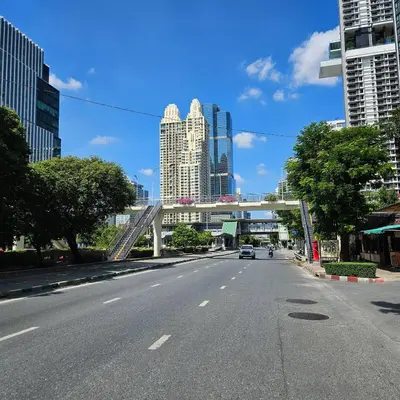an empty street with a bridge in a city at City Living in Bangkok