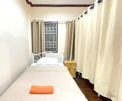 a small bedroom with a bed and a window at TheStarHome Sukhumvit71 in Bangkok