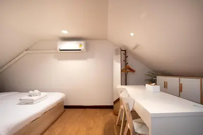 a attic room with two beds and a table at 2BR 1BA Home In Yaowarat 5 Min MRT Nivas Wanit ECO in Bangkok