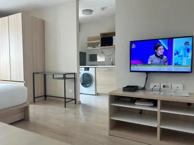 a living room with a flat screen tv on a wall at Gfeel X Elio Sukhumvit64 in Bangkok