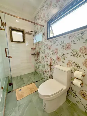 a bathroom with a toilet and floral wallpaper at บ้านคุณนาย BaanKhunNaiPhaholyothin24 in Bangkok