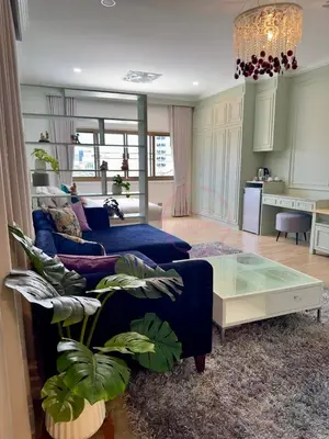 a living room with a blue couch and a table at บ้านคุณนาย BaanKhunNaiPhaholyothin24 in Bangkok