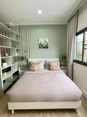 a bedroom with a large white bed and a window at บ้านคุณนาย BaanKhunNaiPhaholyothin24 in Bangkok