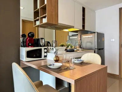 a kitchen with a wooden counter top with a microwave at Contemporary Premier 1BR - Ultra Fast Wifi - BTS Nana in Bangkok