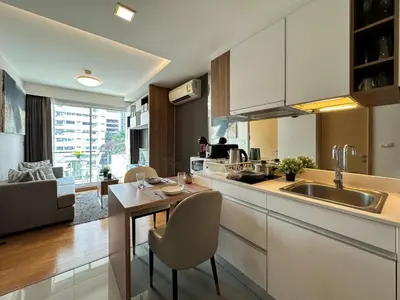 a kitchen with a sink and a table with chairs at Contemporary Premier 1BR - Ultra Fast Wifi - BTS Nana in Bangkok