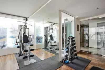 a gym with treadmills and ellipticals and mirrors at Contemporary Premier 1BR - Ultra Fast Wifi - BTS Nana in Bangkok