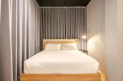 a bedroom with a large bed with white sheets at Rare Bangkok Townhouse Perfect for Groups, 8 mins to Train in Bangkok