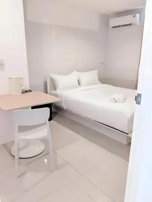 a white room with a bed and a table and a chair at XX Mitr INN Sukhumvit 2 - BTS Nana in Bangkok