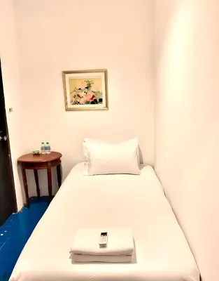 a white bed with a scale on top of it at XX Mitr INN Sukhumvit 2 - BTS Nana in Bangkok